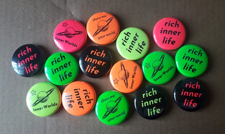 Inner Worlds badges featuring the planet logo, "rich inner life" slogan, and "show me your world" slogan 